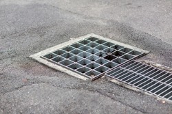 Grille drain of sewer around the street or walkway . Water recirculation system. Wastewater treatment. Grille of the drainage system on the pedestrian sidewalk.	