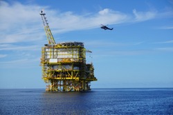 The view of offshore platform with helicopter on the sky at South China Sea.