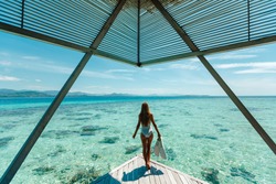 Luxury overwater bungalows Maldives resort woman going snorkeling from private hotel room island.  Travel vacation.  Aqua menthe trendy color of the new year 2020