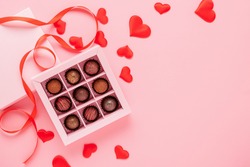 Handmade chocolates truffle in a box on a pink background with valentines. Valentines day concept festive food gifts.