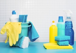 Set of cleaners and detergents, cleaning accessories, blue background with tiles. Concept spring regular cleaning