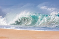powerful wave exploding on a beach in hawaii