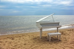 Old white piano on a sandy beach.  Beidaihe, China