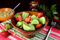 salad fresh cucumber with strawberries and pine nuts