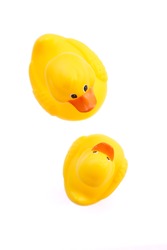 Mother duck and baby duck bath toys on white background; overhead view