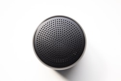 Black Wireless Bluetooth Speaker Isolated on Plain White Background, Viewed From Above;
Top View Showing Perforated Metal Grille Holes.
