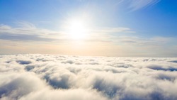 Aerial view White clouds in blue sky. Top. View from drone. Aerial bird's eye. Aerial top view cloudscape. Texture of clouds. View from above. Sunrise or sunset over clouds