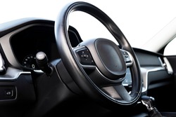 Black luxury modern car Interior. Steering wheel, shift lever and dashboard. Detail of modern car interior. Automatic gear stick. Part of leather seats with stitching in expensive car
