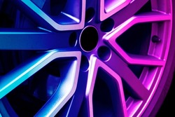 Car alloy wheel texture background in blue and pink tones. New alloy wheel for a car. Modern alloy rim. Car wheel disc.