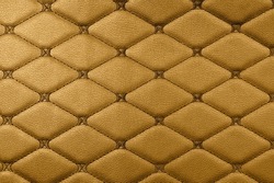 Brown leather texture. Part of perforated leather details. Orange perforated leather texture background. Texture, artificial leather with diagonal stitching.