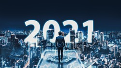 Business technology concept, Professional business man walking on future network Tokyo city background with new year 2021 text and futuristic interface graphic at night in Japan