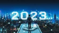 Business technology concept, Professional business man walking on future network Bangkok city background with new year 2023 text and futuristic interface graphic at night in Thailand