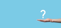 Male hand holding question mark icon on blue background.Banner with copy space. Place for text