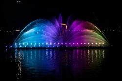 A dancing fountain, or fountain, formed by a controlled ascending and descending rainbow-like lights.  And the color reflecting on the water.