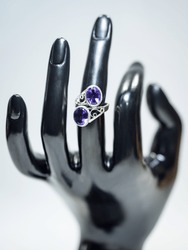 Amethyst gemstone silver ring on black plastic hand