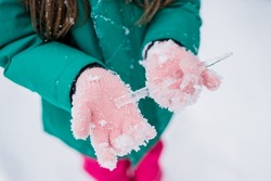 Outdoor winter activities for kids. Close up of child girl hands holding icicle. Kids spending time outside and environments provide wonderful hands-on experiences in nature during the winter