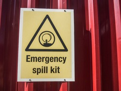 View of emergency spill kit signage at oil and gas warehouse