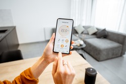 Controlling home heating temperature with a smart home, close-up on phone. Concept of a smart home and mobile application for managing smart devices at home