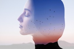 Double exposure photo with woman silhouette and sunset sky with mountains and birds. Freedom and travel concept