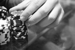Man's hand pick a chips. Poker concept. Black and white photography