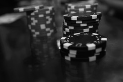Poker black chips on the table with reflection  in a black a white.