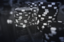 Poker black chips on the table with reflection  in a black a white. Selective focus
