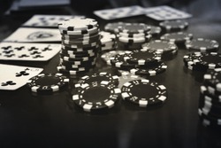 Black and white poker set. White chips are chaotic and cards in a black a white photography. Vignetting effect