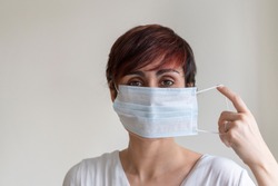 Prevent contagious viral diseases like corona virus covid 19. Stop propagation and use caution measures. Portrait of nurse explaining steps of wearing a face mask covering possible germs in mouth.