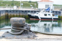 Horizontal front view of nautical knot tied to the harbor. Detail of maritime knot of a boat tied to the harbor anchor. Sea and maritime concept.
