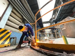 The man grinding metal. Worker grinding steel outdoor.