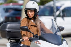 Woman with safety helmet riding a motorcycle