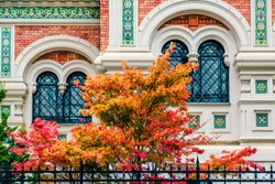 Russian Orthodox Cathedral Saint Nicholas in Vienna, Austria. Traditional Russian architecture in old style. Painted windows with latice and decorations close-up. Autumn trees with colorful leaves.
