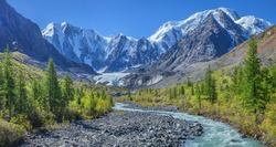 Picturesque mountain landscape, Altai, Russia. Gorge with a mountain river, rocky slopes, snow-capped peaks. Summer travel, hiking. 