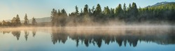 Panoramic view of forest lake in morning fog, summer travel
