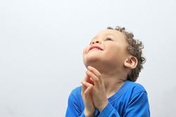 little boy praying to God stock image with hands held together with open eyes with people stock photography stock photo