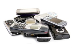 old mobile phones piled up on a table with white background no people stock photo