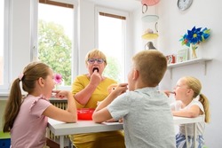 Children speech therapy concept. Children practicing correct pronunciation with a female speech therapist. Group therapy.