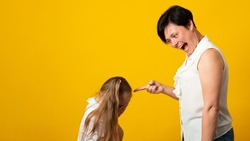 Mother screams shouts at little daughter scolding her. Kid not listen ignoring mom close cover her ears with fingers. Complicated relationships with child. 