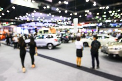 blur background of motorshow, car show room. Abstract blurred image people in cars exhibition show