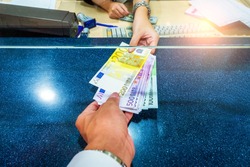 Female hand with money in cash department window. Currency exchange concept. Euro banknote. EUR . cash on counter bank. Hand giving cash and hand receiving cash. payday paying cashier access
