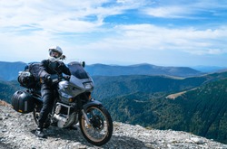 Motorcyclist man and Adventure Motorbike on the top of the mountain. Motorcycle trip. World Traveling, Lifestyle Travel vacations sport outdoor concept, copy space. Transalpine Romania