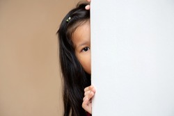 Little Asian kid peeking at the corner