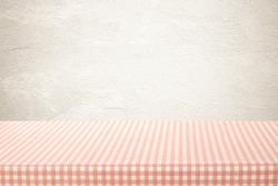 Tablecloth in pink and white pattern, perspective, over brown gradient kitchen wall background, Empty table top, shelf, counter mock up for food and product display montage, template
