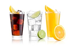 Glasses of cola and orange soda drink and lemonade sparkling water on white background with ice cubes lemons and lime bits