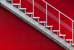 gray metal stair on the red wall. minimalism concept