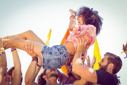 Happy hipster woman crowd surfing at a music festival
