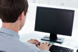 Back view of a businessman working with a computer in his office