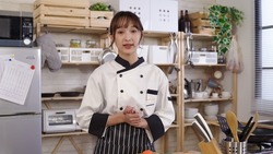 female chef recording video for her channel at home kitchen while prepping for food with knife. looking at camera, asian woman vlogger sharing cooking tips on social media with hand gesture.