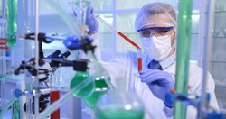 Biochemist Man Pouring Liquid in Vials Glass with Micro Pipette in Medical Laboratory Room