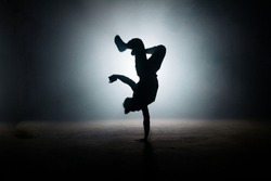 b-boy performing kick on yhe dark street. stylish position. dance form